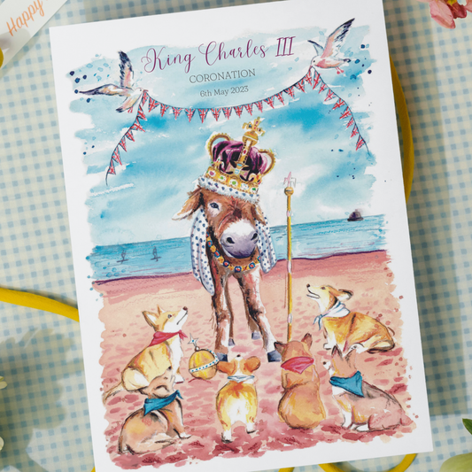 Limited edition postcards featuring a donkey wearing the crown jewels on Cleethorpes beach, surrounded by royal corgis to commemorate the coronation of King Charles III.