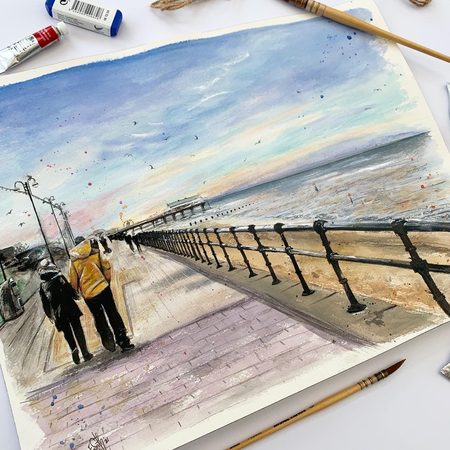 An original watercolour painting of a couple walking along Cleethorpes promenade towards the Cleethorpes Pier on an early winter's evening. Painted by local Grimsby artist, Eve Leoni Smith.