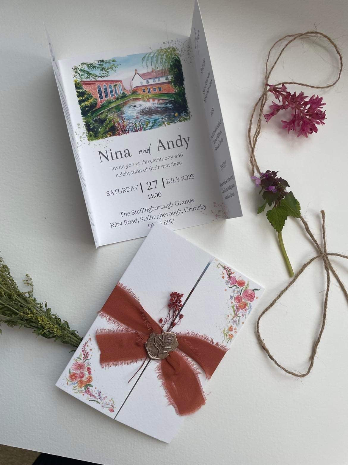 Luxury gatefold invitations designed by Eve Leoni Art, featuring a watercolour illustration of Stallingborough Grange and embellished with silk ribbon and a wax seal.