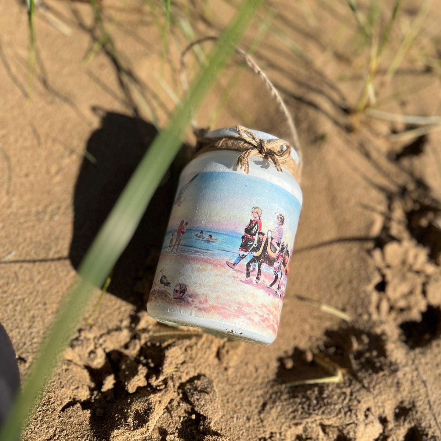 A decorative jar featuring watercolour artwork by Eve Leoni Smith on Cleethorpes Beach.