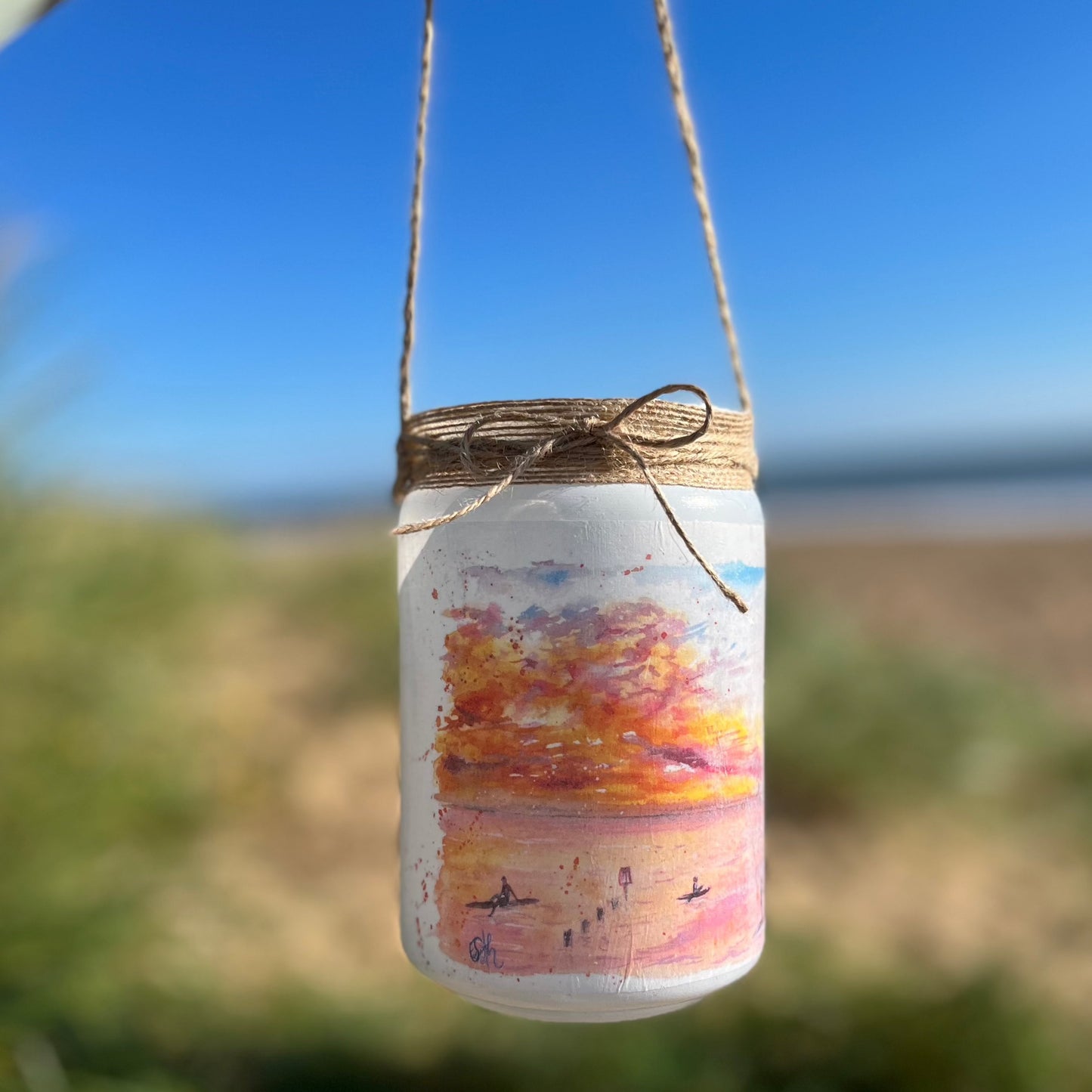 A firefly jar decoupaged with watercolour artwork of Humberston Fitties Beach at sunset, painted by Eve Leoni Smith and decorated by Jollypotz.