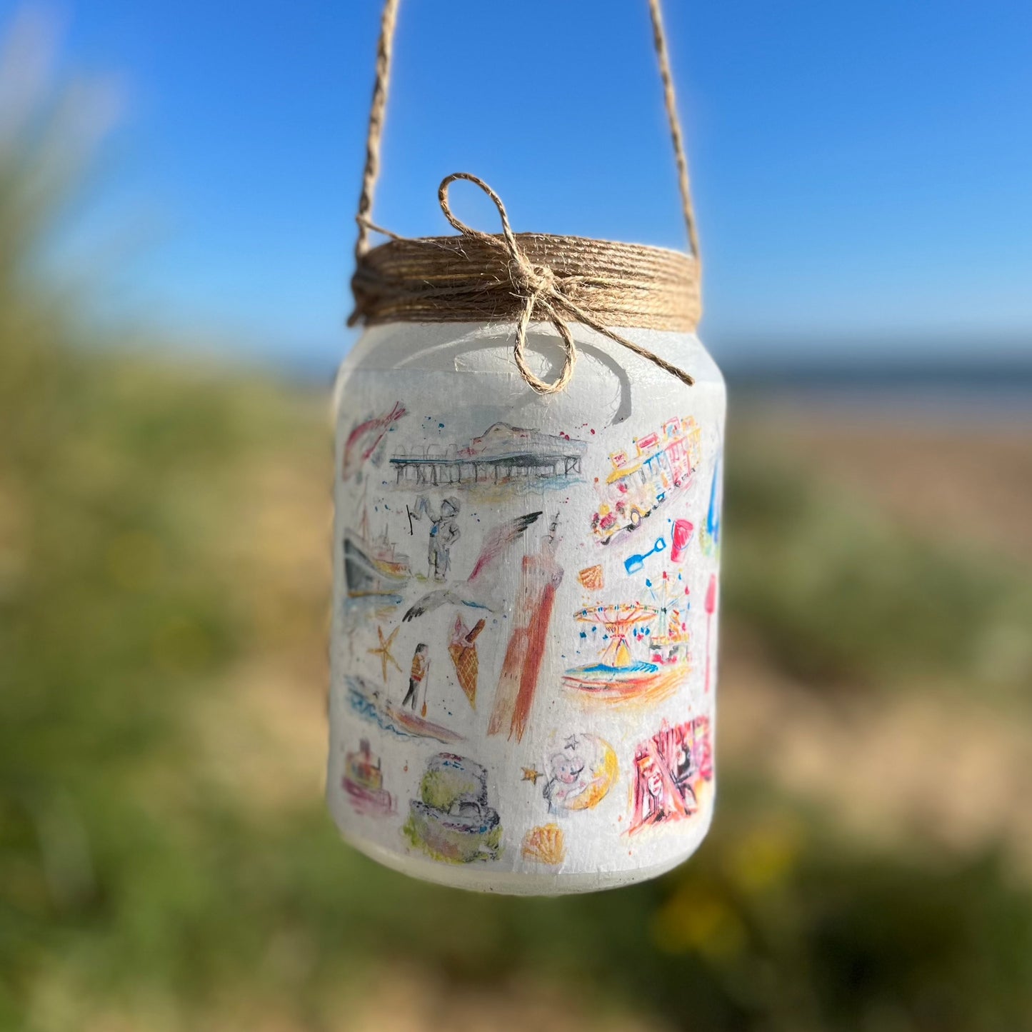 A decoupaged jar featuring watercolour illustrations of local landmarks in Grimsby and Cleethorpes by local artist, Eve Leoni Smith and Jollpotz.
