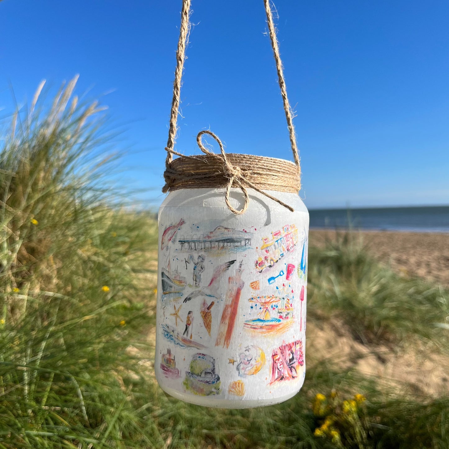 A decoupaged jar featuring watercolour illustrations of local landmarks in Grimsby and Cleethorpes by local artist, Eve Leoni Smith and Jollpotz.