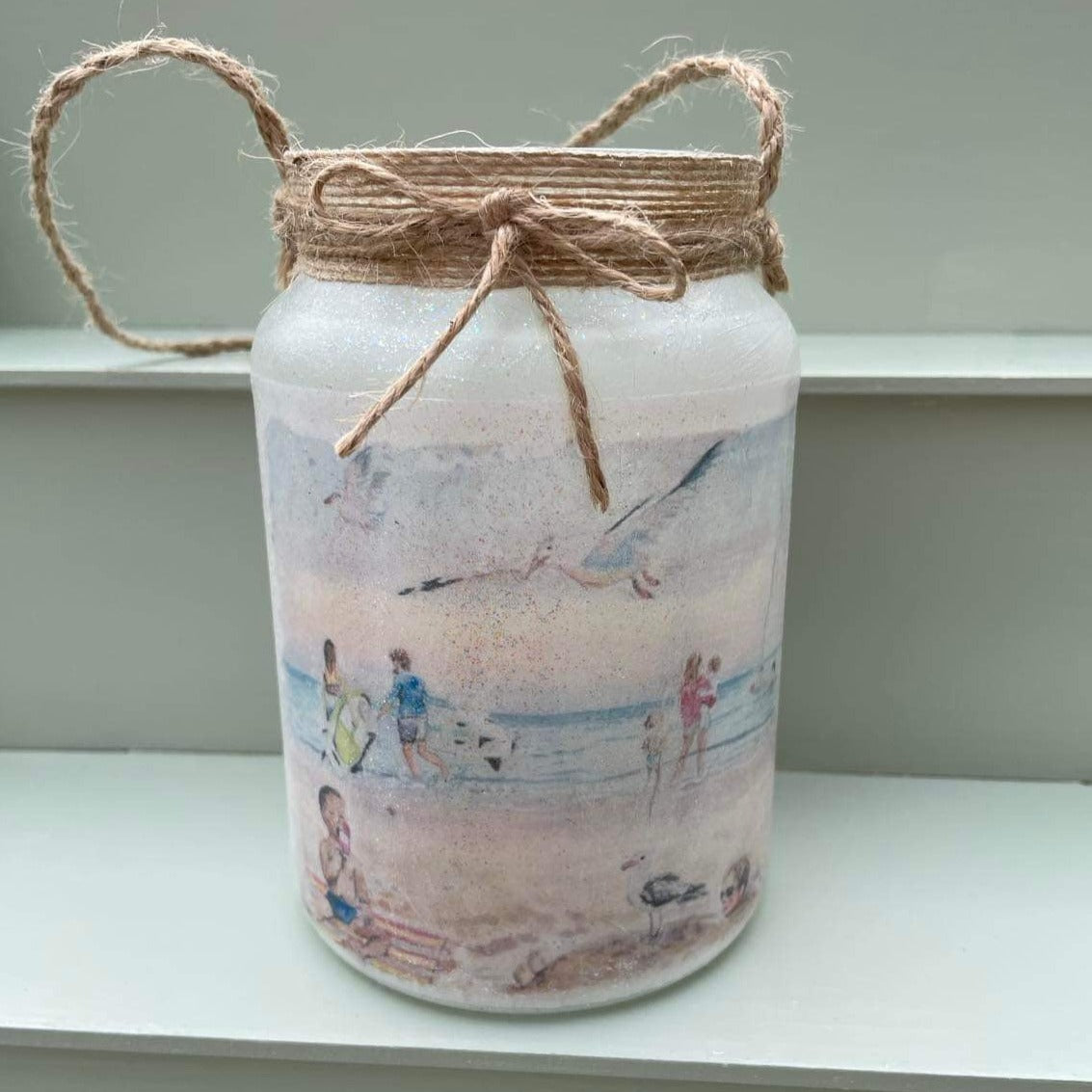 Decoupaged firefly jar featuring watercolour artwork of Cleethorpes beach by Eve Leoni Art.