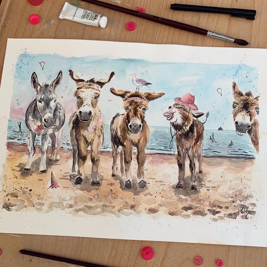 An original watercolour painting of the charming Cleethorpes donkeys on Cleethorpes beach by local Grimsby artist, Eve Leoni Art.