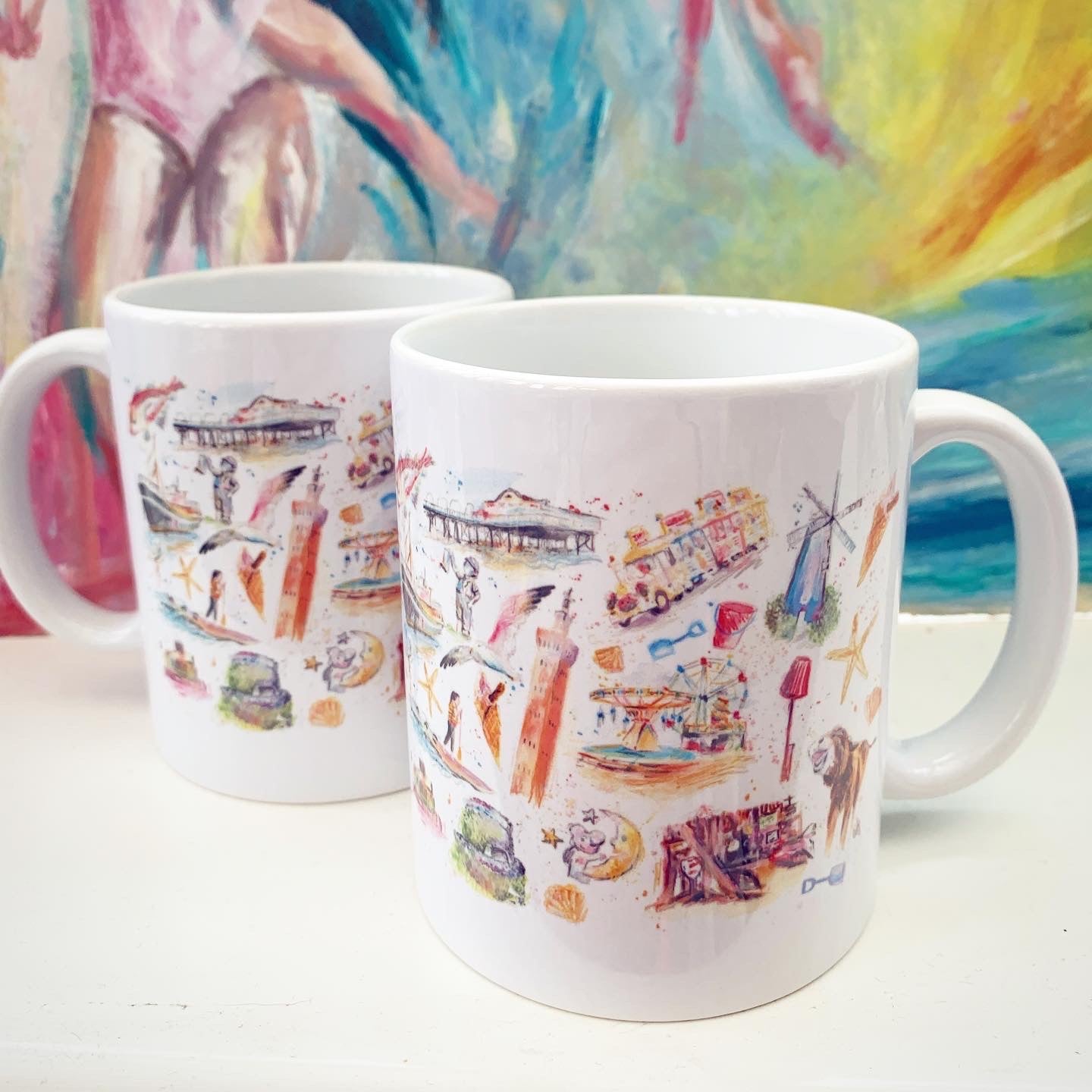 Two 11oz ceramic mugs featuring illustrations of local landmarks by Cleethorpes artist, Eve Leoni Smith.
