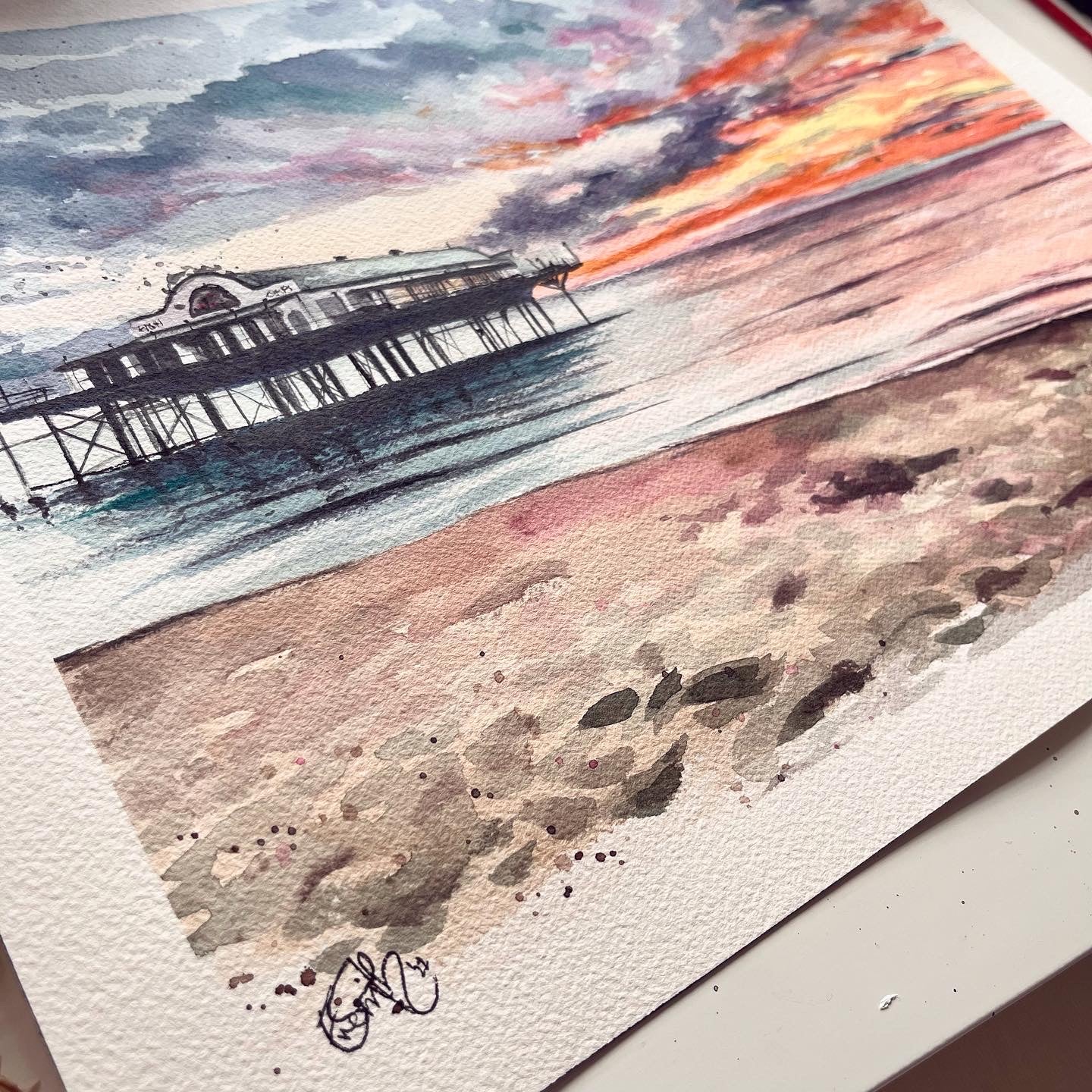 An original watercolour painting of the Cleethorpes pier at sunset on Cleethorpes beach, by Lincolnshire artist, Eve Leoni Smith.
