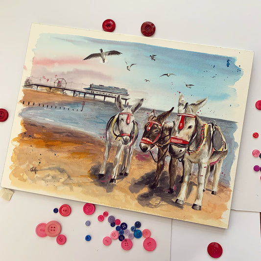 An original watercolour painting of some donkeys on Cleethorpes beach, with the pier and sea in the background. Painted by local Grimsby artist, Eve Leoni Smith. 