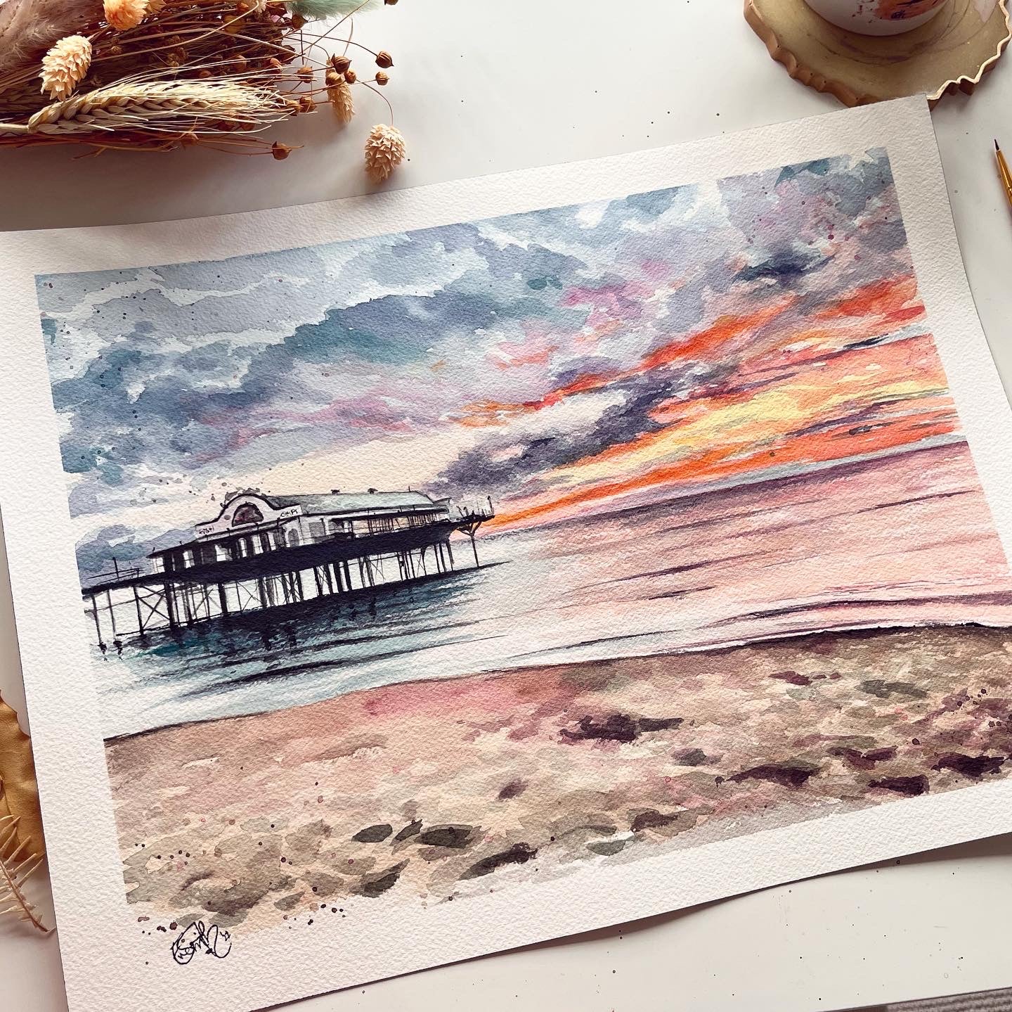 An original watercolour painting of the Cleethorpes pier at sunset on Cleethorpes beach, by Lincolnshire artist, Eve Leoni Smith.
