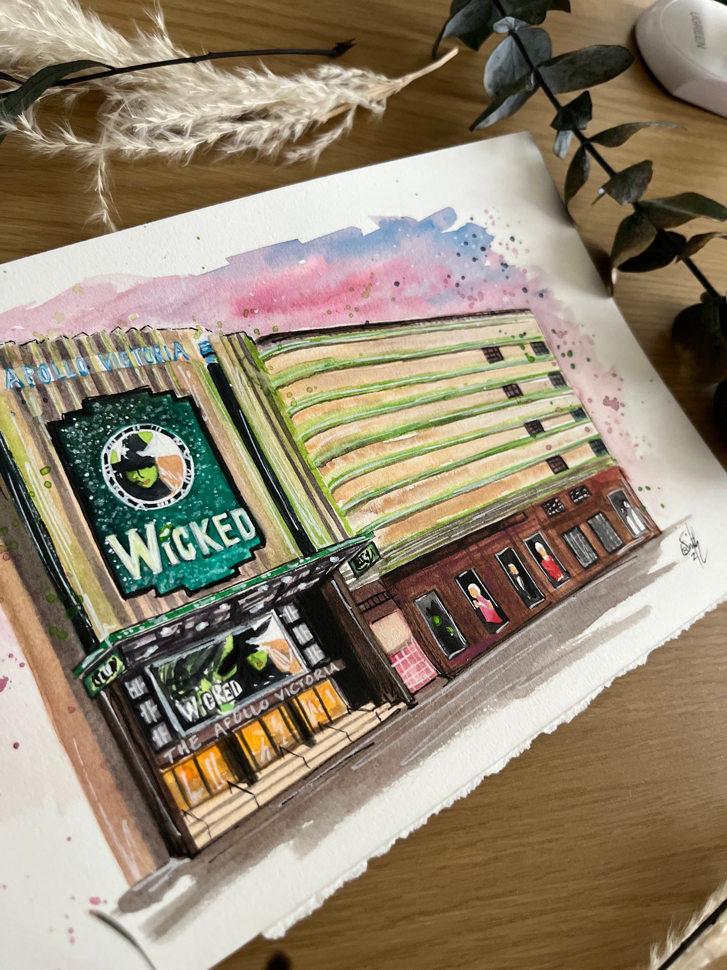 A watercolour illustration of the Apollo Victoria Theatre featuring Wicked the Musical by artist in London, Eve Leoni Smith. 