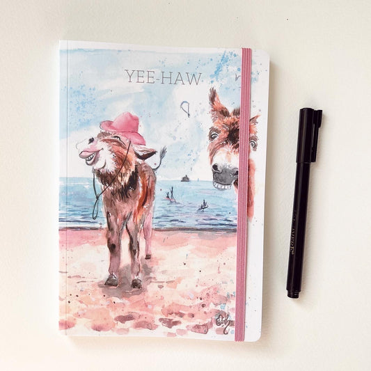 A luxury, perfect bound notebook featuring a popular original painting of the Cleethorpes donkeys by Cleethorpes artist, Eve Leoni Smith.