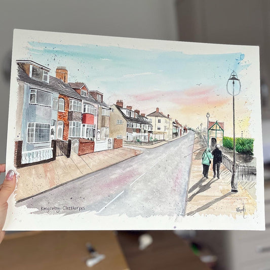 An original watercolour painting of the Kingsway, Cleethorpes, with a couple walking along. This original artwork was painted by local Cleethorpes artist, Eve Leoni Smith. 