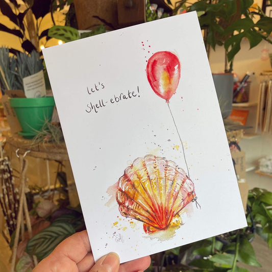 A celebratory greetings card designed by Eve Leoni Smith, featuring a watercolour illustration of a shell holding a birthday balloon. 
