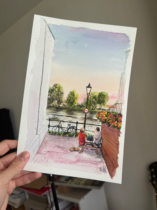 Watercolour painting of the River Thames in Chiswick, featuring a couple enjoying a pint of beer during the sunset. Painted by local artist, Eve Leoni Smith. 