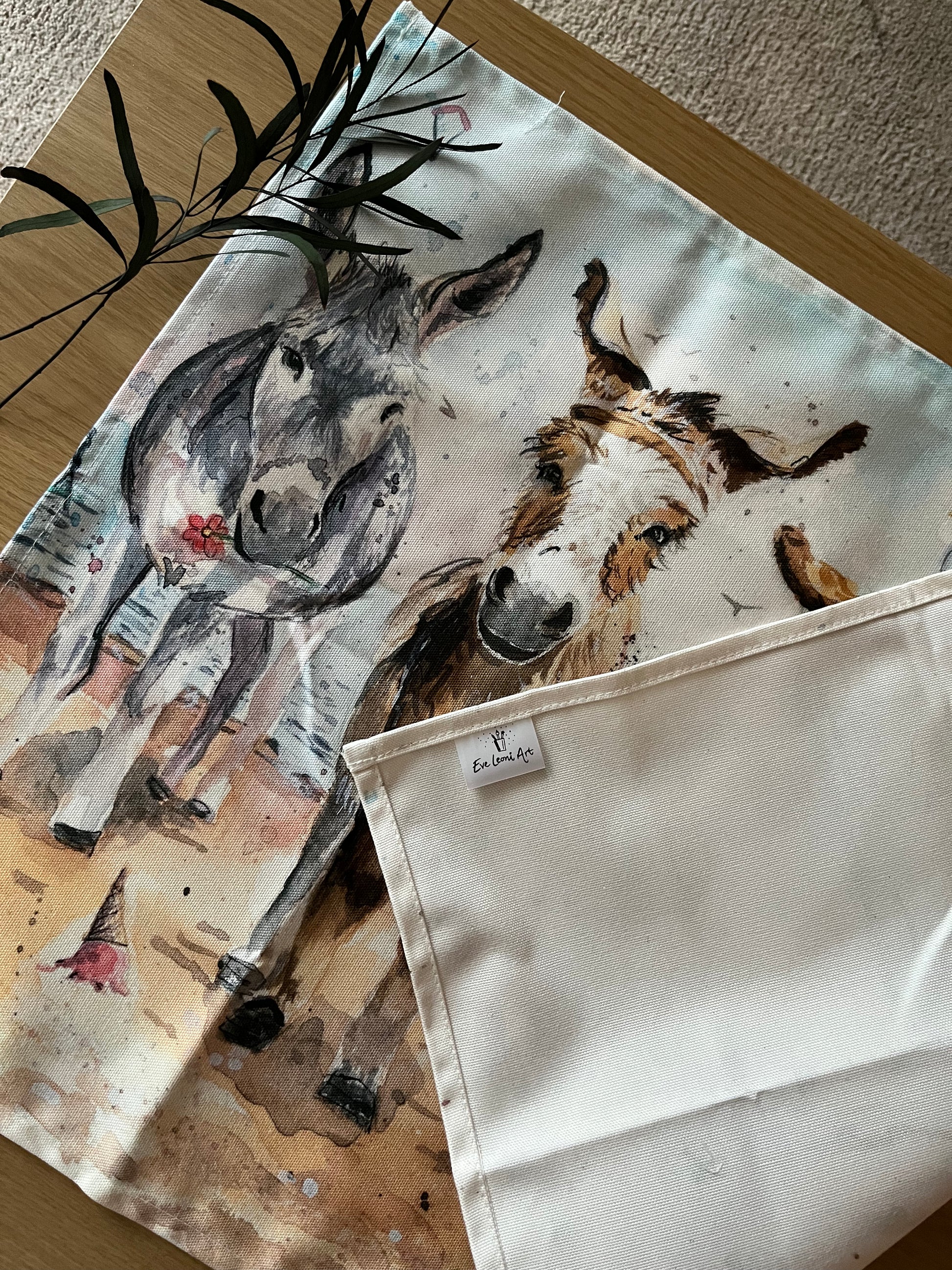 An organic tea towel featuring original watercolour artwork of the Cleethorpes donkeys by local Grimsby artist, Eve Leoni Smith.