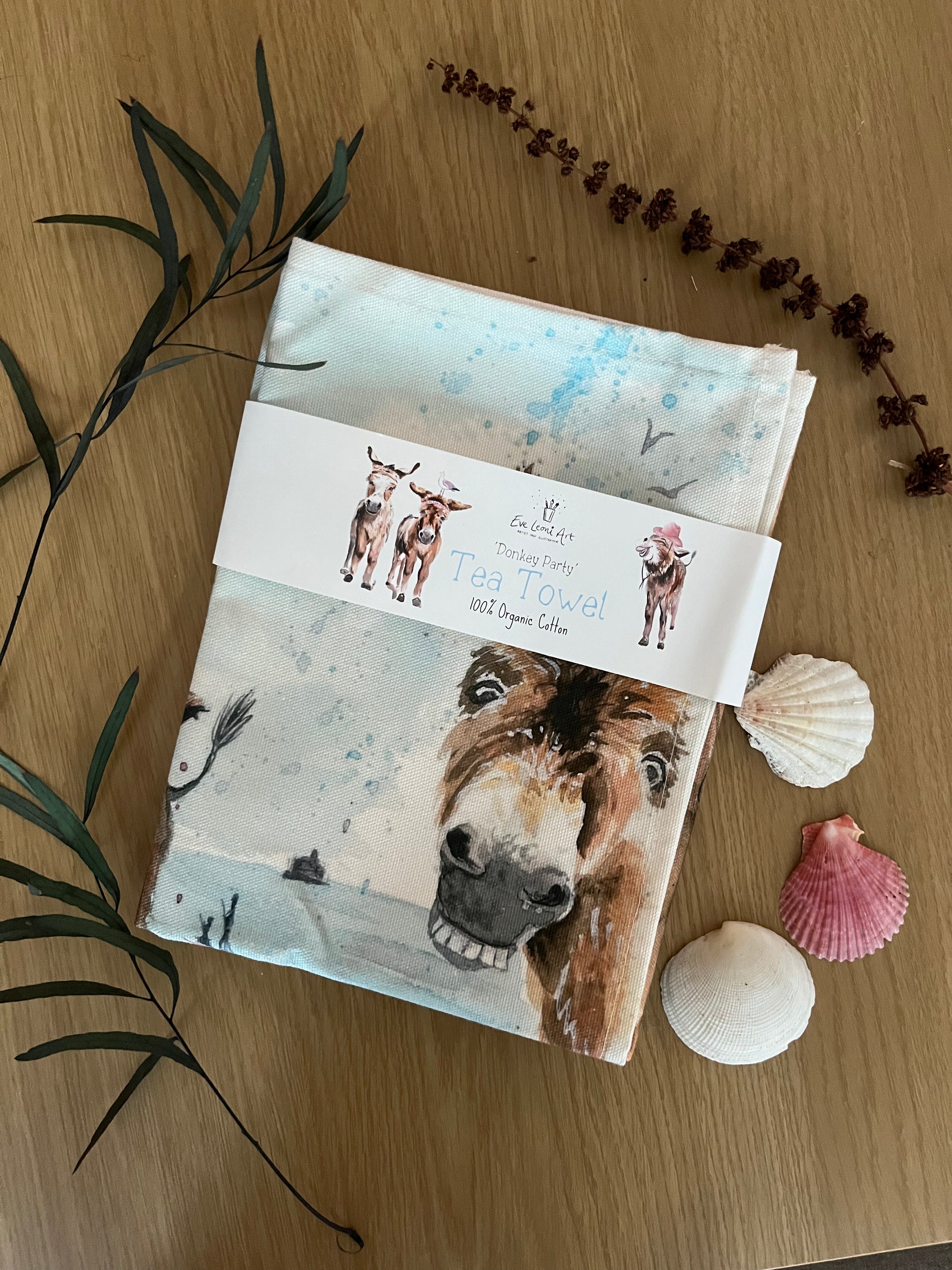 An organic tea towel featuring original watercolour artwork of the Cleethorpes donkeys by local Grimsby artist, Eve Leoni Smith.