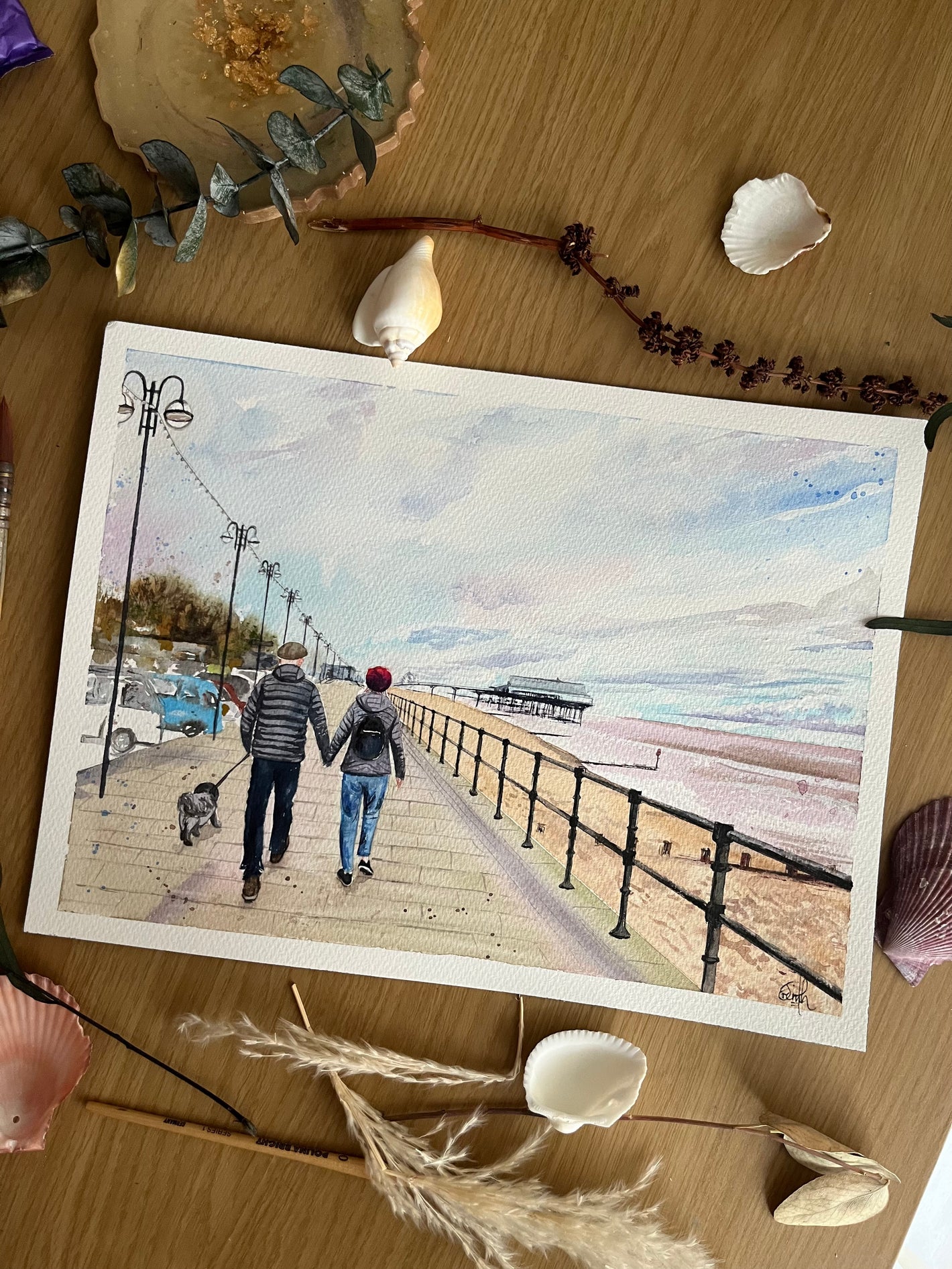 A watercolour landscape painting of a couple walking along Cleethorpes Seafront, painted by Grimsby artist, Eve Leoni Smith.