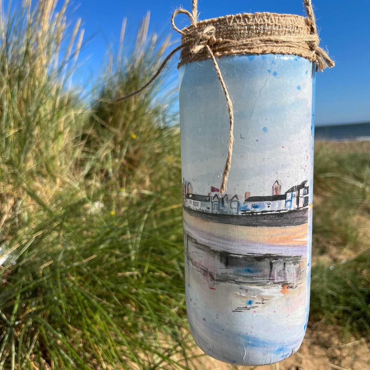 A decorative jar featuring watercolour artwork of the Cleethorpes Seafront by Eve Leoni Smith,  a local artist from Grimsby.