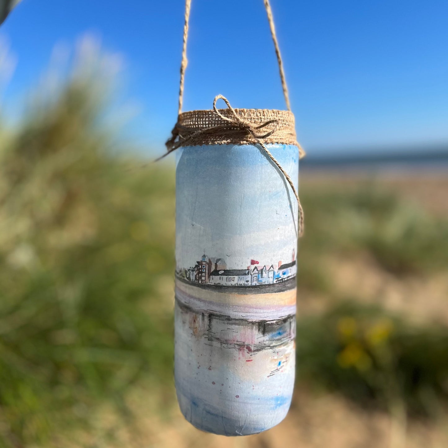 A decorative jar featuring watercolour artwork of the Cleethorpes Seafront by Eve Leoni Smith,  a local artist from Grimsby.