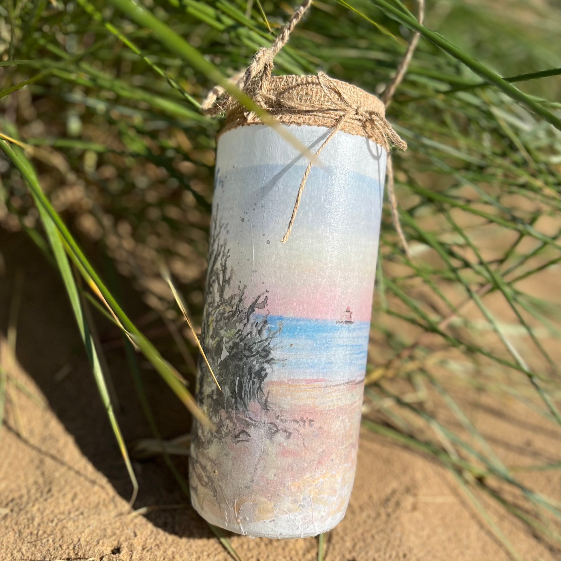 A decoupaged jar on Cleethorpes beach, featuring watercolour artwork of the Humberston Fitties by Eve Leoni Smith and Jollypotz.