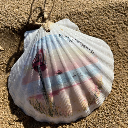 A decoupaged shell on Cleethorpes beach, featuring watercolour artwork of Humberston Fitties Beach by Eve Leoni Smith and Jollypotz.