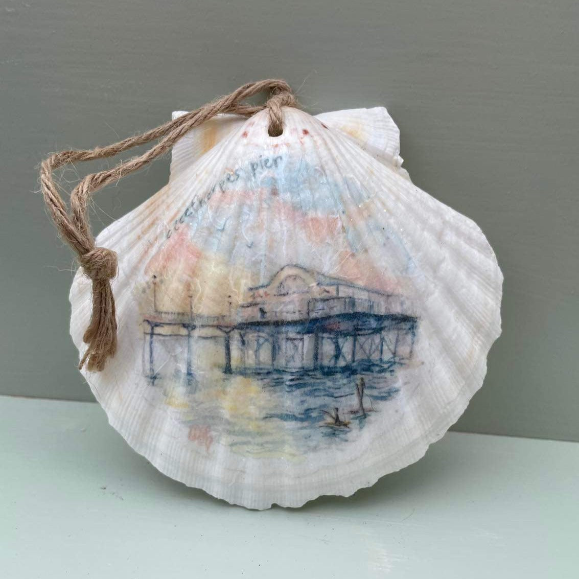 A decoupaged shell featuring a watercolour illustration of the Cleethorpes Pier by local businesses Eve Leoni Art and Jollypotz.