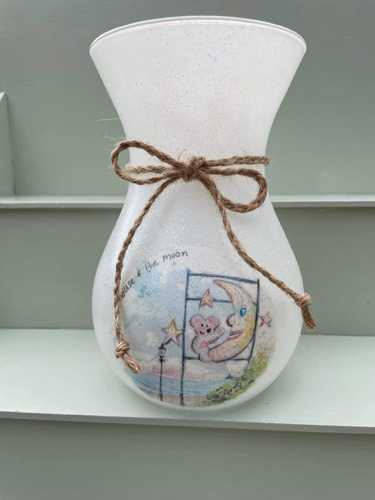 A decoupaged vase on Cleethorpes beach, featuring watercolour artwork of the Mouse and the Moon by Eve Leoni Smith and Jollypotz.