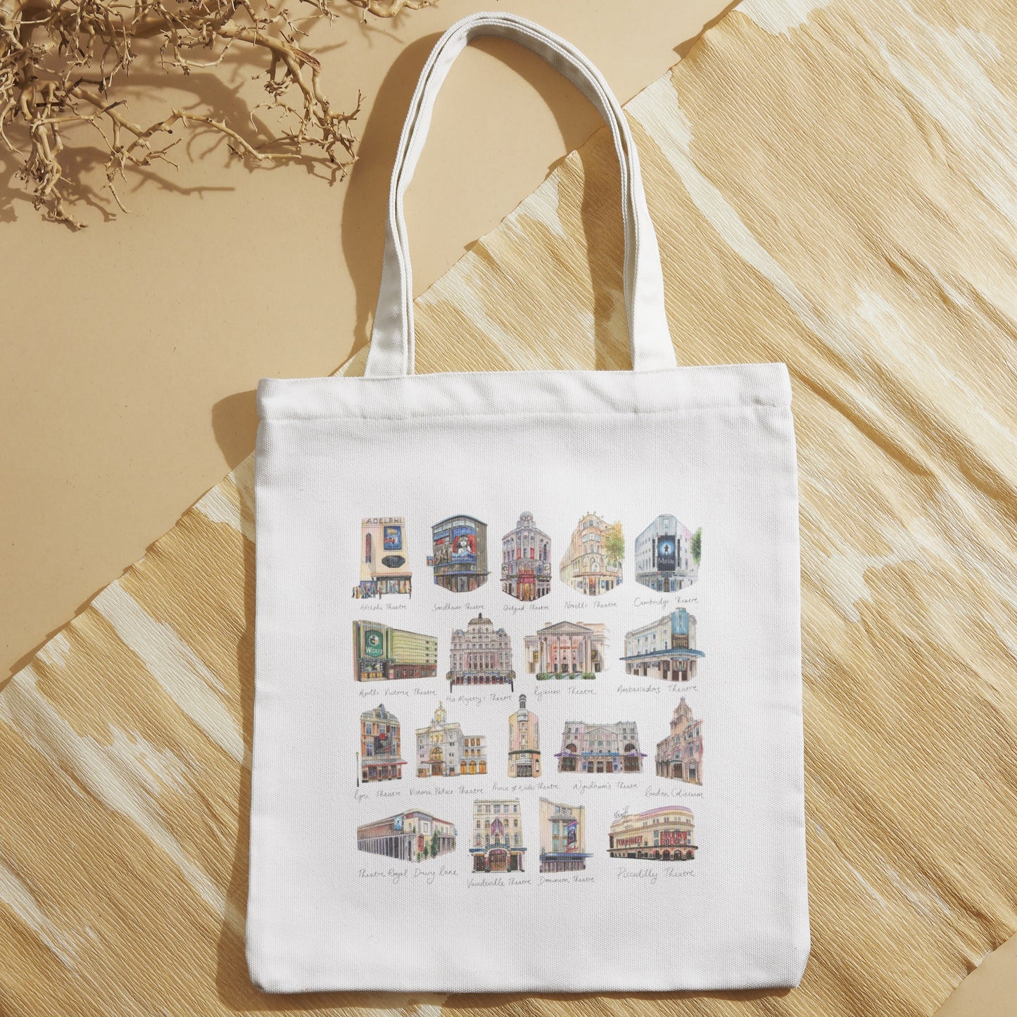 Natural tote bag with colorful West End Theatres by Eve Leoni Art on a beige surface