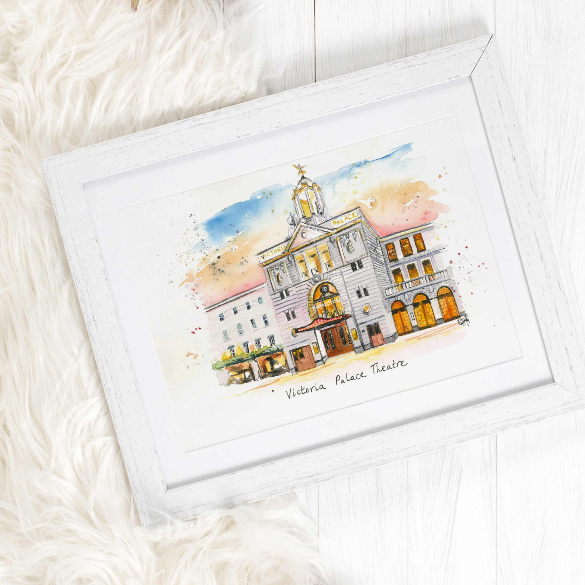 A framed watercolour print of the Victoria Palace Theatre, home to Hamilton the Musical, by local artist and performer, Eve Leoni Smith.